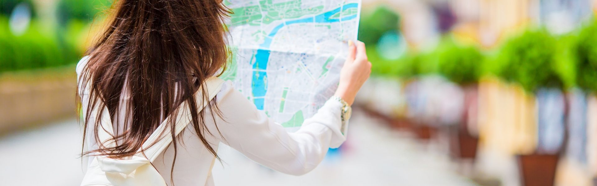 Happy young woman with a city map in Europe. Travel tourist woman with map in Prague outdoors during